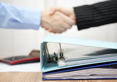 A Lot Of Documentation In Binder With Handshake In Blur