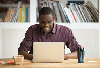 Man looking at laptop and smiling